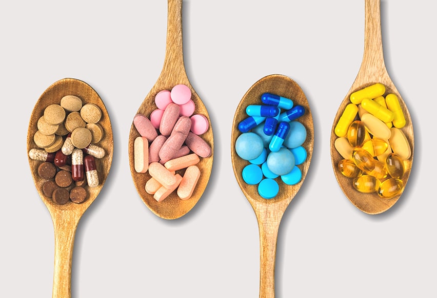 Four spoonfuls of vitamin supplements that have different colors. If you’re experiencing frequent headaches accompanied by other TMJ symptoms a dentist can offer you a drug free treatment option and forgo Vitamins, Minerals for Reducing Migraines