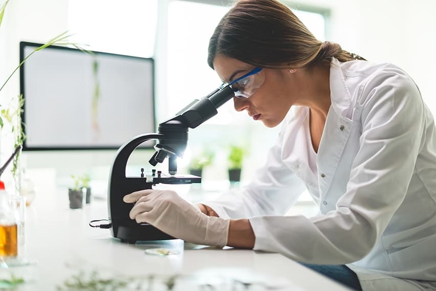 A young scientist exams nano technology through a microscrope in a lab. Nanotechnology refers specifically to engineering performed on a nano scale - for your mouth.