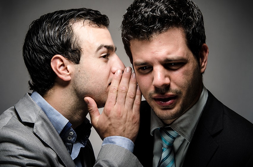 Two men in business suits share a secret. Vertigo or dizziness are common symptoms of TMJ because the temporomandibular joint is adjacent to the inner ear, which plays a large role in regulating balance.