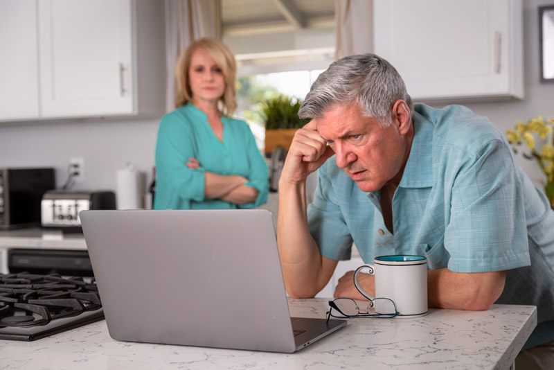 Dental Patient At His Laptop, Struggling With Bills