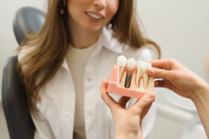 Dental Patient Getting Shown A Dental Implant Model During Her Consultation in Mohegan Lake, NY