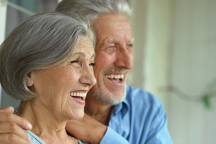 an elderly couple smiling together