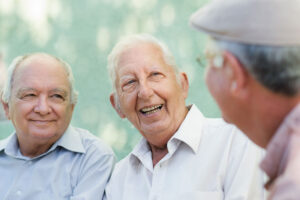 three older men talking and smiling after getting full mouth dental implants.
